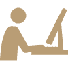 A simple beige icon of a person sitting at a desk and using a computer monitor.