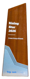 A wooden award plaque with the text "Rising Star 2026, Crown Group of Hotels" and the Trip.com Group logo at the bottom, featuring blue and gray geometric accents—a mark of excellence among hotels in Gower Street.